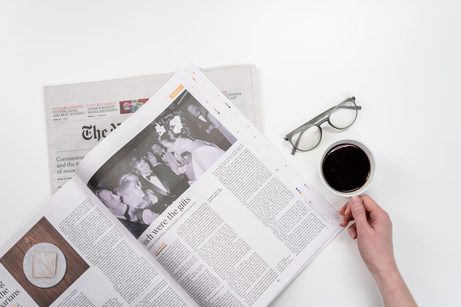 Overhead view of newspaper reading with coffee and glasses on a white table. — Baccarat: A Game That Brings Elegance, Excitem