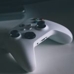 A detailed shot of a white gaming controller on a desk surface, perfect for tech and gaming themes. — Vivatbet Sportsbetting: