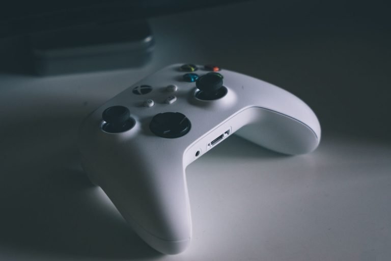 A detailed shot of a white gaming controller on a desk surface, perfect for tech and gaming themes. — Vivatbet Sportsbetting: